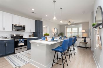 An open kitchen with an island and blue bar stools